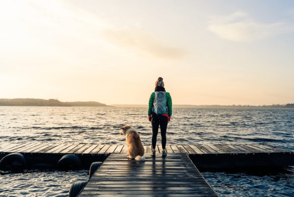 Pensive girl and dog at lake